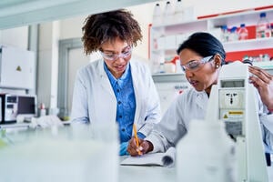 Two female clinicians reviewing data in a lab
